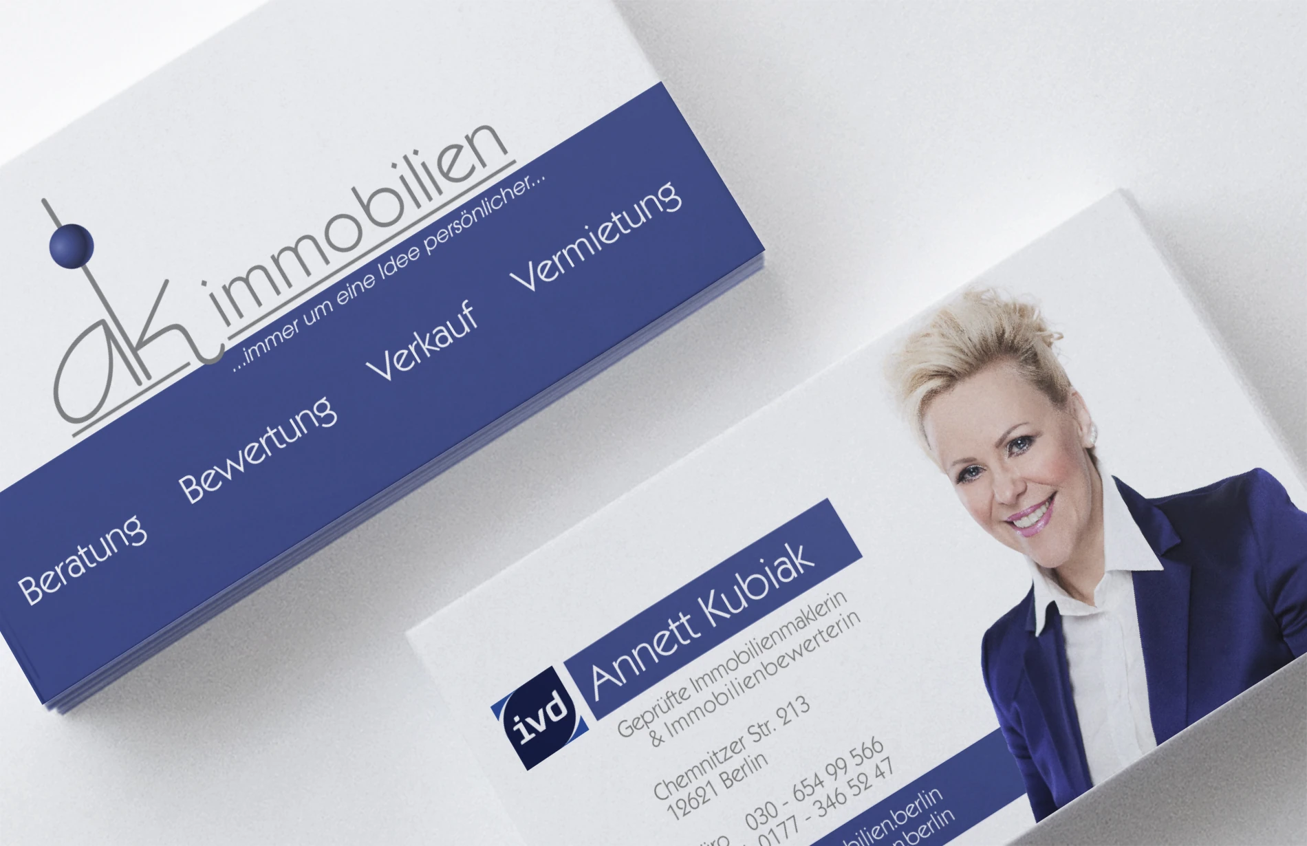 Visitenkarte von AK Immobilien mit Porträt und dunkelblauem Farbfeld