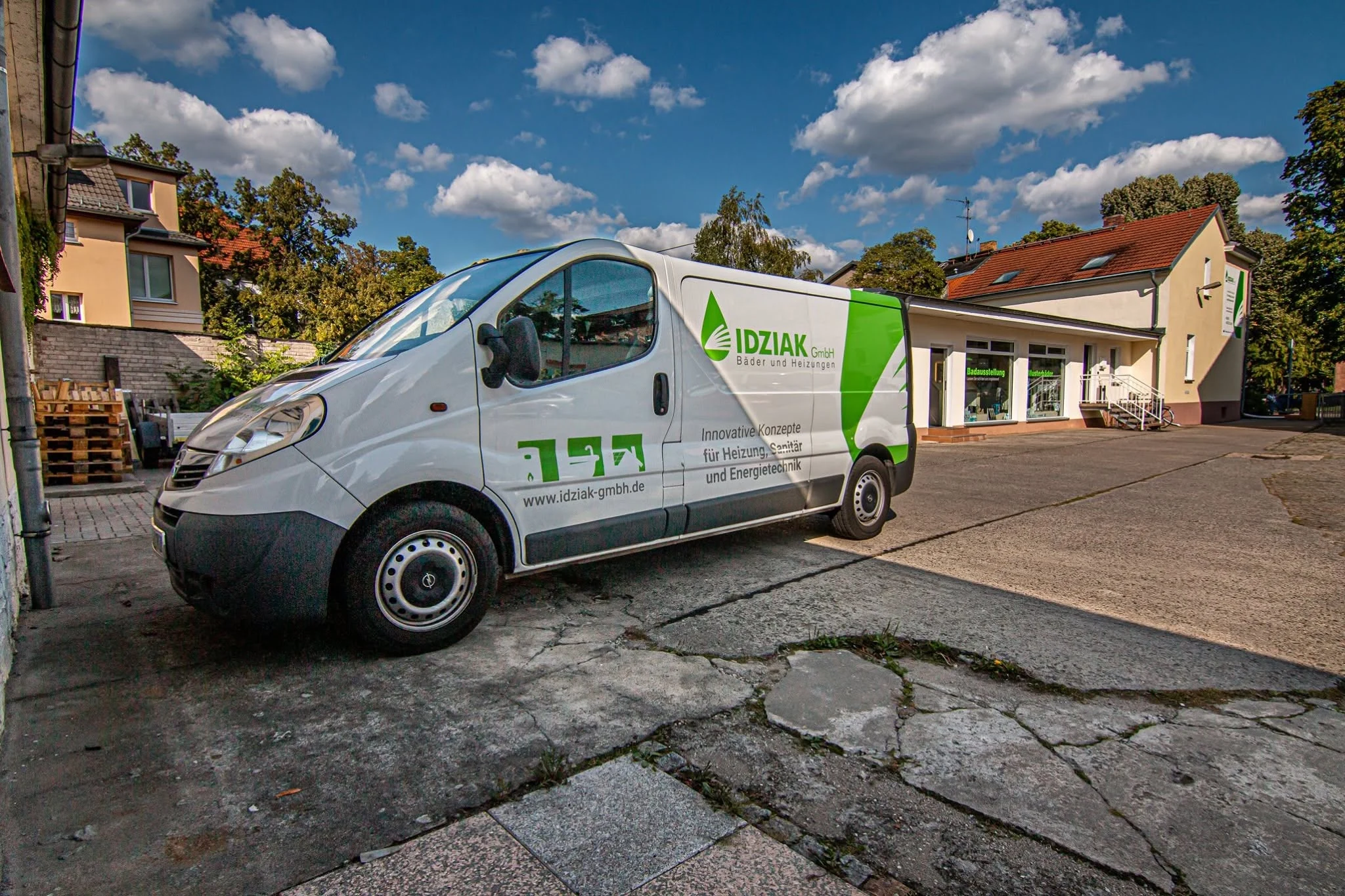 Transporter der IDZIAK GmbH mit grüner Fahrzeugbeschriftung für Bäder und Heizungen
