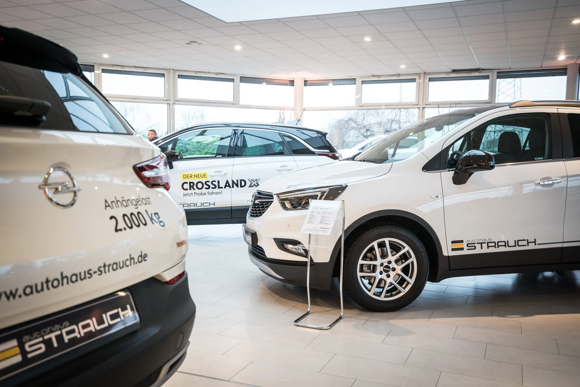 Opel-Fahrzeuge im Autohaus Strauch mit STRAUCH-Beschriftung und Angebotsaufklebern