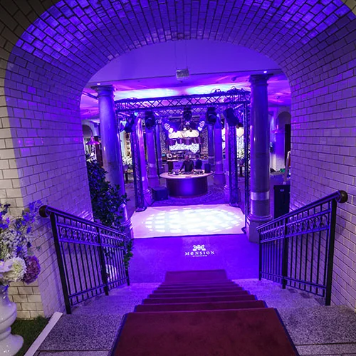 Beleuchteter Eingang zur GQ Jubiläumsparty in Berlin mit Treppe und Torbogen