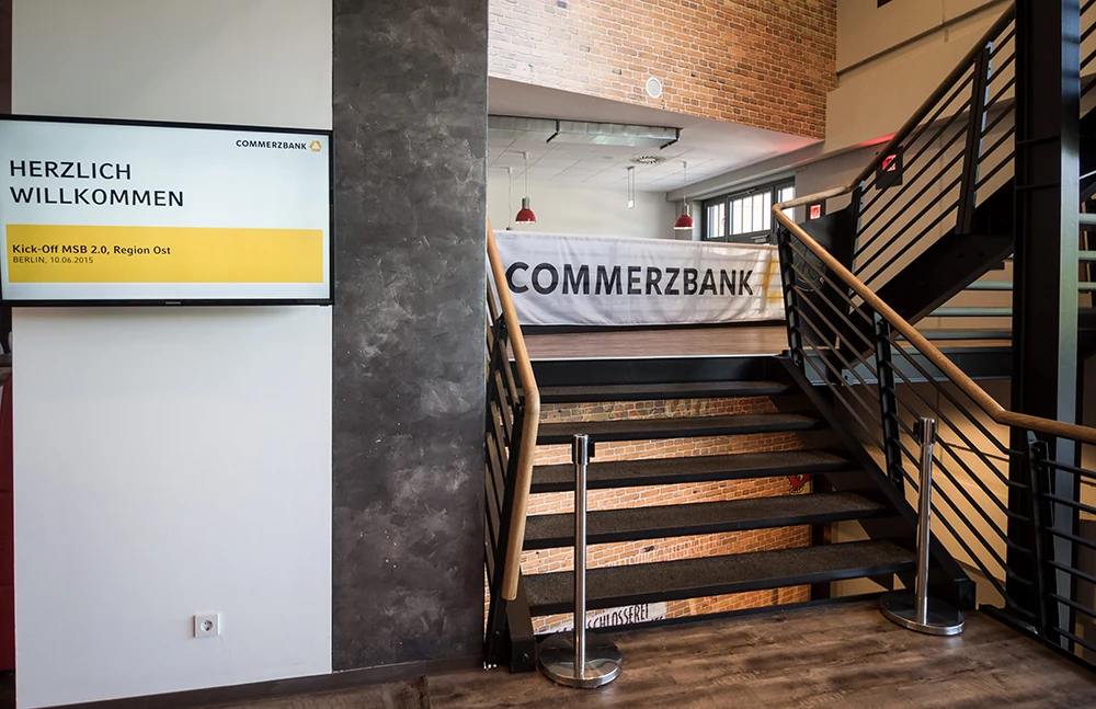 Commerzbank-Stele und Willkommensscreen an der Treppe im Foyer