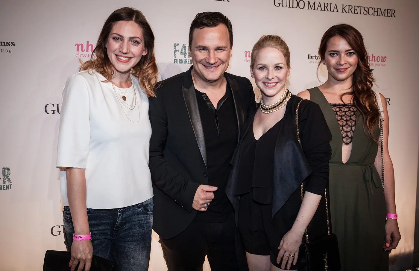 Guido Maria Kretschmer mit Gästen vor der Pressewand zur After-Show-Party der Fashion Week Berlin