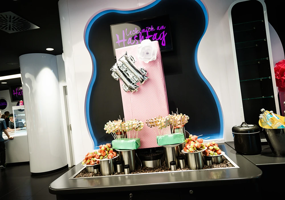 Foodstation mit Neonschriftzug „Leck mich am Hashtag“ und Fingerfood in der World of Cyberobics
